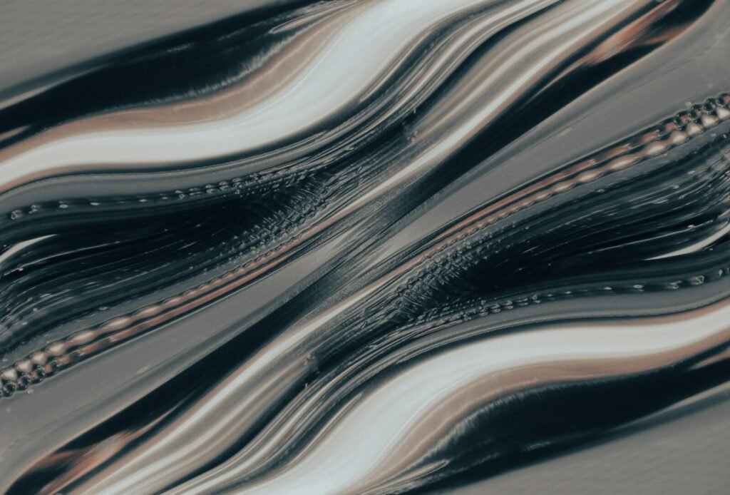 Abstract flowing waves of dark grey and metallic silver liquid